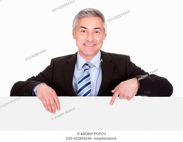 Mature Businessman Pointing At Placard