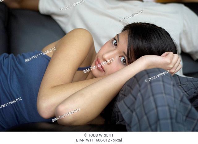 Portrait of Asian woman laying on boyfriendÆs leg