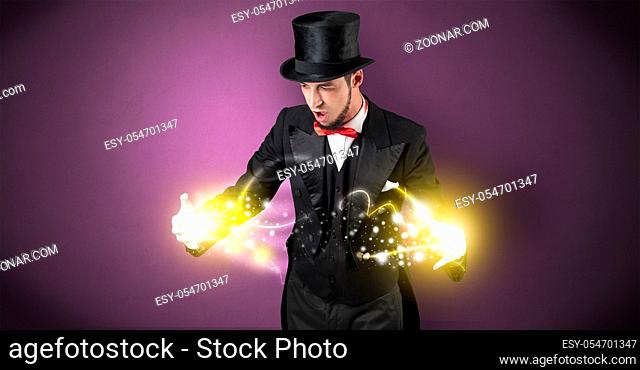 Magician holding his sparkling power between his two hand