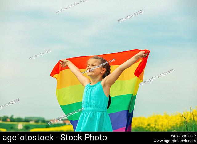 Happy girl holding rainbow flag