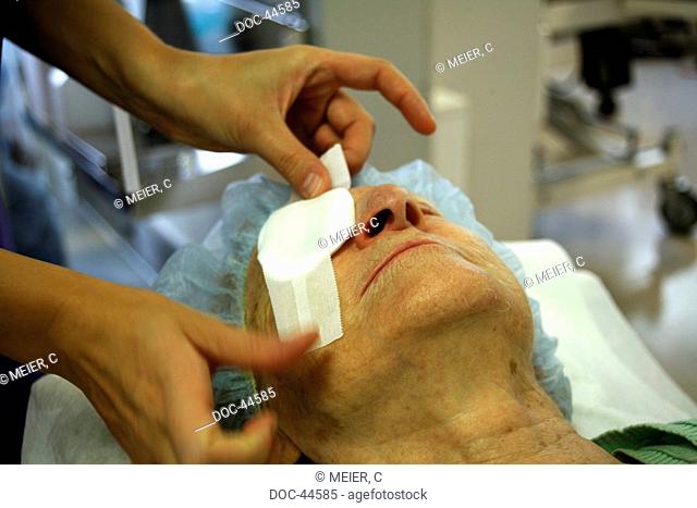 eye cataract , nurse is applying a dressing to a patients eye after an eye-surgery