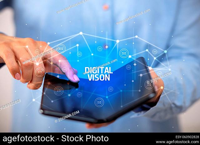 Businessman holding a foldable smartphone with DIGITAL VISON inscription, new technology concept