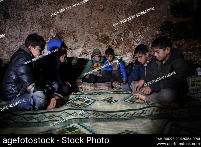 23 February 2020, Syria, Idlib: Syrian children pictured inside a cave at Taltouna village. At least eight families live in an ancient deserted cave after being...