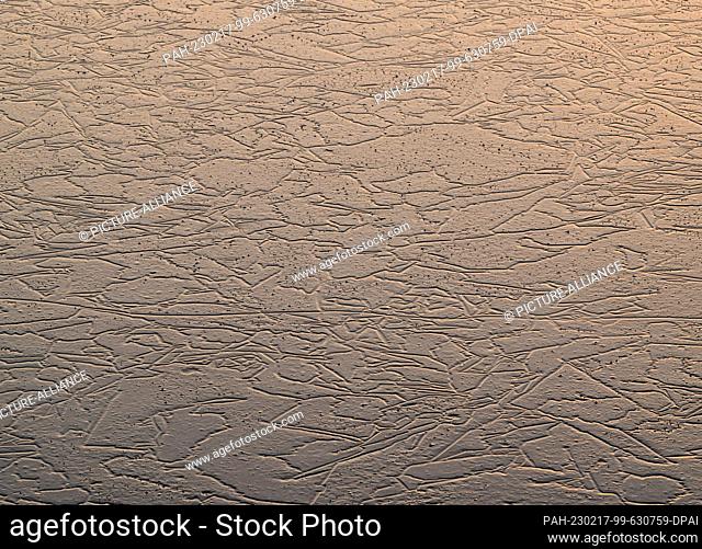 15 February 2023, Brandenburg, Lebus: Patterns can be seen in the ice of a lake against the light. Photo: Patrick Pleul/dpa