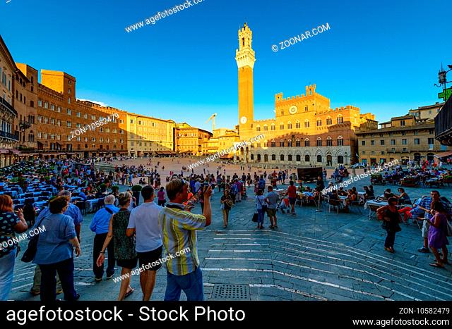 Siena, Italy - August 23, 2012: Tourists visiting Piazza del Campo in Siena, Italy. The historic centre of Siena has been declared by UNESCO a World Heritage...