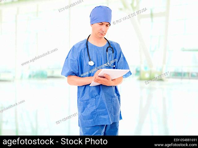 male doctor thinking with his notes, at the hospital