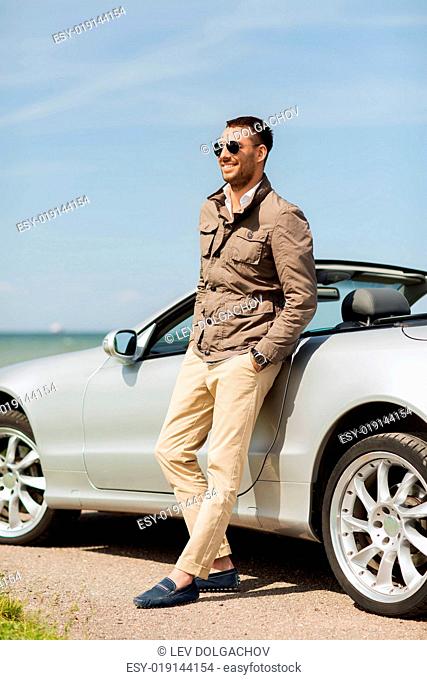 auto business, transport, leisure and people concept - happy man near cabriolet car outdoors