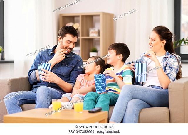 happy family with popcorn watching tv at home