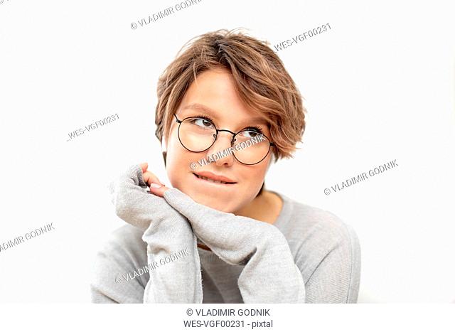 Portrait of thinking young woman with glasses and wireless earphones