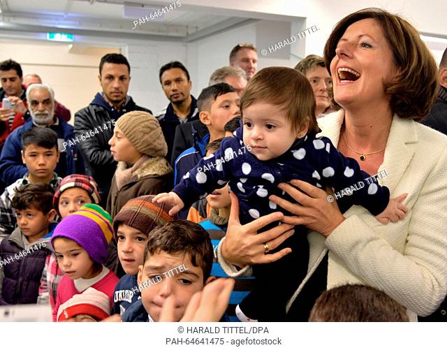 Malu Dreyer (R), premier of the German state Rhineland-Palatinate, holds the ten-month-old Elen Youssef from Syria in her arms during Christmas celebrations...