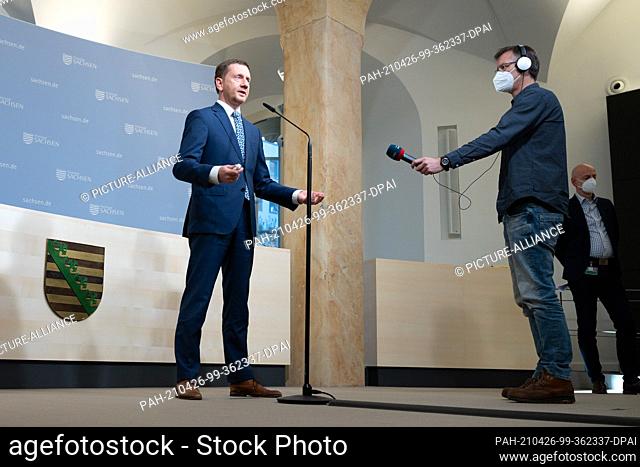 26 April 2021, Saxony, Dresden: Michael Kretschmer (CDU, l), Prime Minister of Saxony, speaks during a press statement in the Saxon State Chancellery