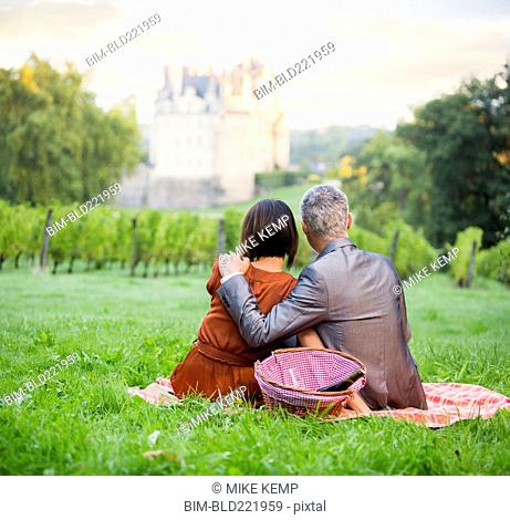 Caucasian couple enjoying picnic in vineyard