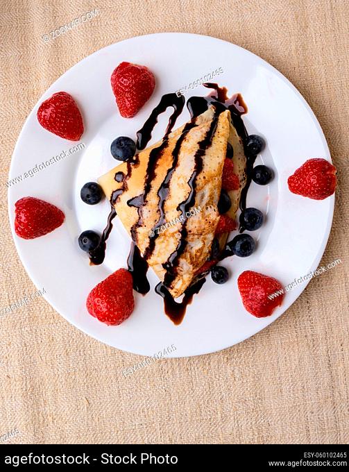 fresh pancake with fruits and chocolate syrup