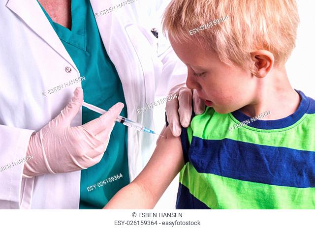 little boy given an injection by the family doctor. The female doctor gives the child an injection in the upper arm. It can be both a vaccination or as part of...