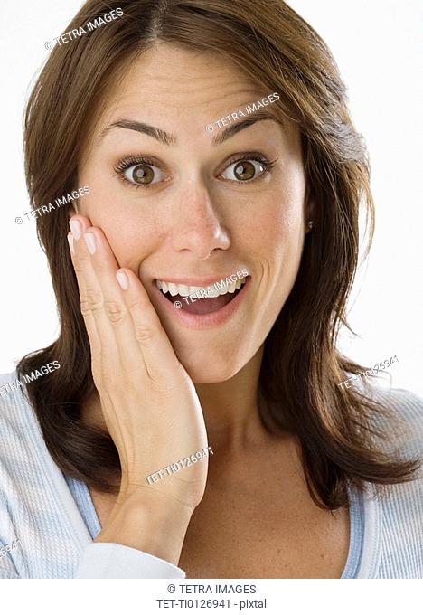 Woman looking surprised with hand on cheek