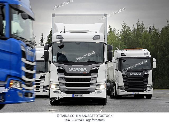 Turku, Finland. August 23, 2019. Scania G500 semi trailer parks between two other trucks while blue truck passes. Scania in Finland 70 years tour