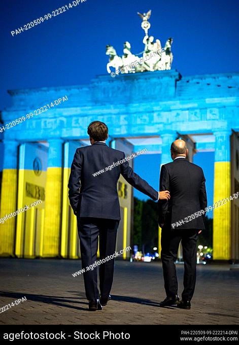 09 May 2022, Berlin: German Chancellor Olaf Scholz (r, SPD) and French President Emmanuel Macron stand in front of the Brandenburg Gate after a meeting