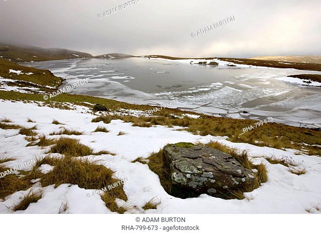 Melting snow on the moorland above an ice covered Llyn y Fan Fawr in winter, Black Mountain, Brecon Beacons National Park, Wales, United Kingdom, Europe