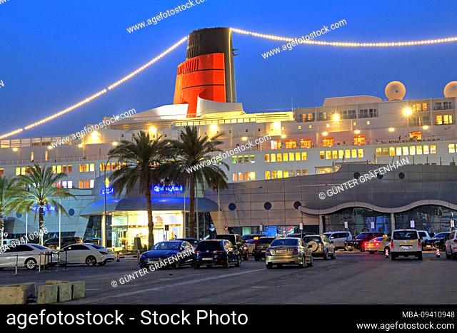 Illuminated hotel and museum ship Queen Elizabeth 2 (QE2) at the pier at dusk, Dubai, Persian Gulf, United Arab Emirates