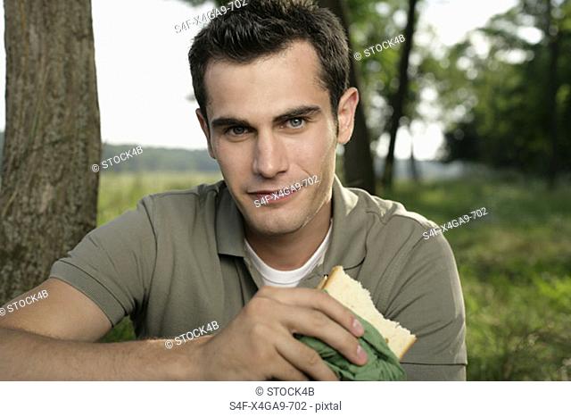 Mid adult man eating a sandwich