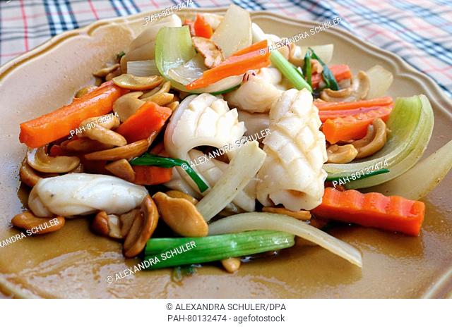 A dish of squid with cashew nuts and vegetables is seen on a table at a restauarant in Karon Beach, Thailand 12 March 2016