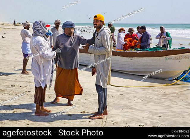 Fishermen hauling in nets on the beach, Salalah, Salalah, Dhofar, Oman, Asia