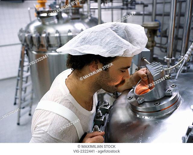 Chemist checking drug vats at a pharmaceutical production plant, - 01/01/2010