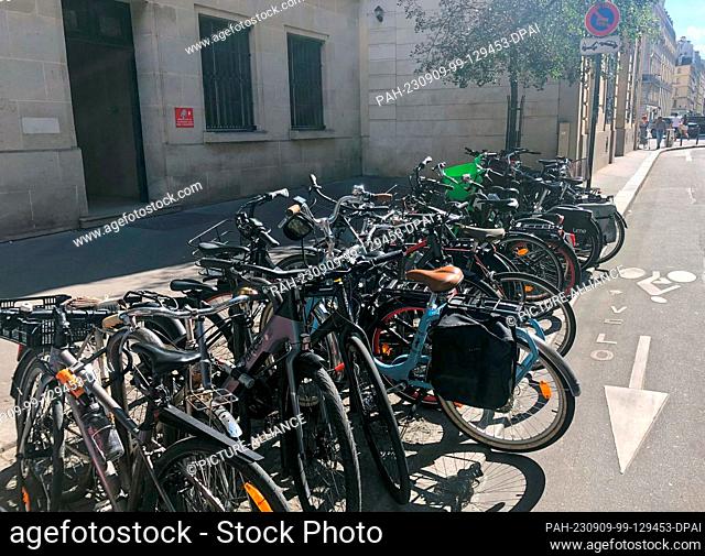 08 September 2023, France, Paris: Bicycles are parked at a parking space next to a bike lane. In the first three months of the year, bicycle use increased by 37