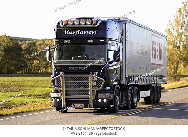 Salo, Finland - October 5, 2018: Purple Scania R500 semi truck of Pernion JR-Trans Ky hauls curtainsider trailer along autumnal highway in the evening