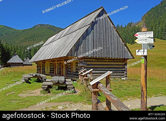 Old wooden huts, signepost, meadow