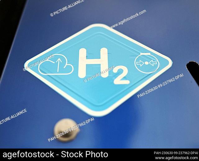 29 June 2023, Baden-Württemberg, Karlsruhe: The inscription ""H2 "", taken on a vehicle powered by a hydrogen engine, at an information event on hydrogen engine...