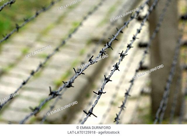 Close up of a barbed wire fence with a concrete post surrounding a compound within Auschwitz 1 concentration camp. Auschwitz concentration camp is an important...