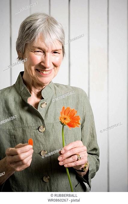 Portrait of an elderly woman holding a flower