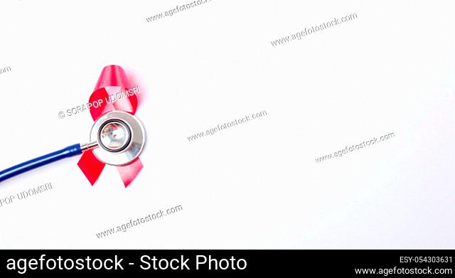 Breast cancer month concept, flat lay top view, pink ribbon and stethoscope on white background with copy space for your text