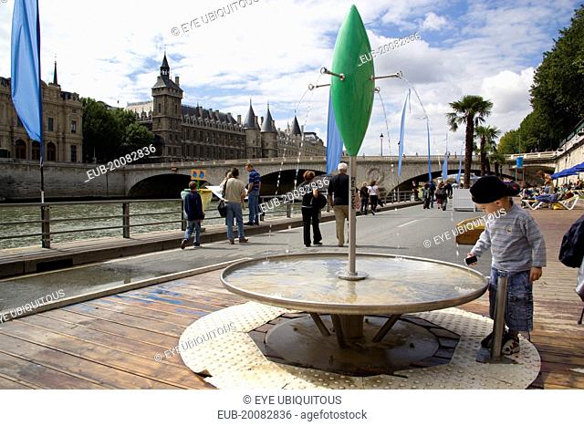 The Paris Plage urban beach. A small boy at one of the many free drinking water fountains on the Voie Georges Pompidou, a usually busy road closed to traffic