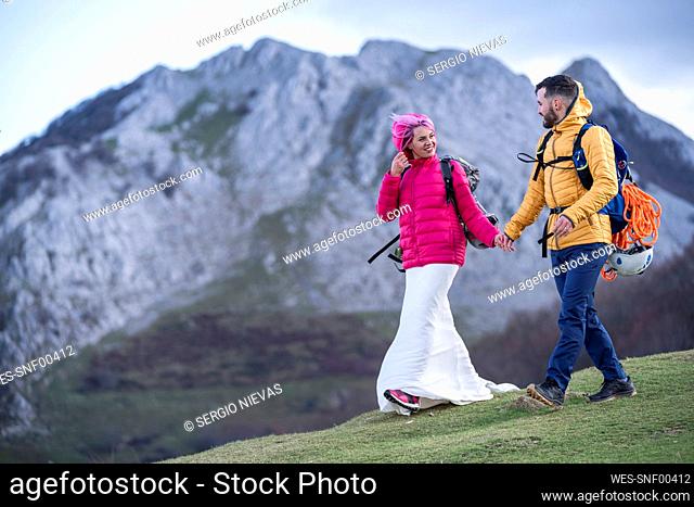 Bridal couple hiking with backpacks, Urkiola mountain, Spain
