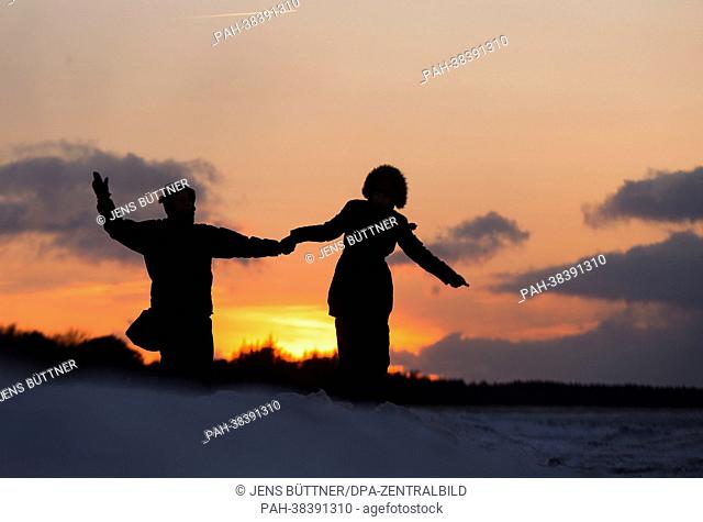 People sillhouette against the setting sun in Zingst, Germany, 23 March 2013. Meteorologists predict sunny weather with temperatures around zero degrees Celsius...