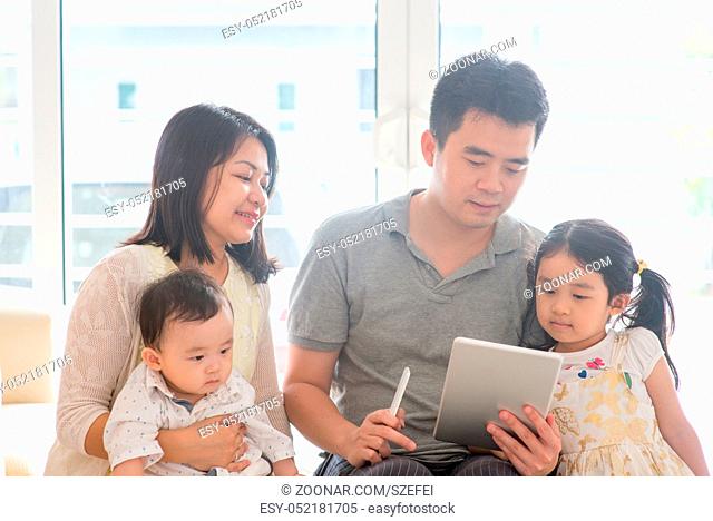Chinese adult scanning QR code with smart phone. Asian family at home, natural living lifestyle indoors