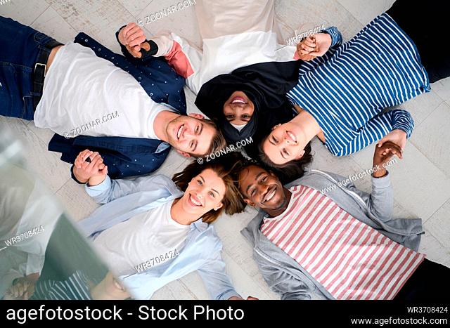 a top view of a diverse group of people lying on the floor and symbolizing togetherness