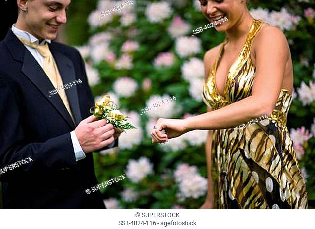 Teenage boy giving wrist corsage to his girlfriend in senior prom, Seattle Hill-Silver Firs, Snohomish County, Washington State, USA