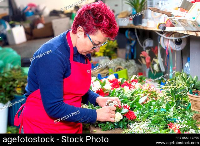 Portrait of female florist creating beautiful bouquet at flower shop