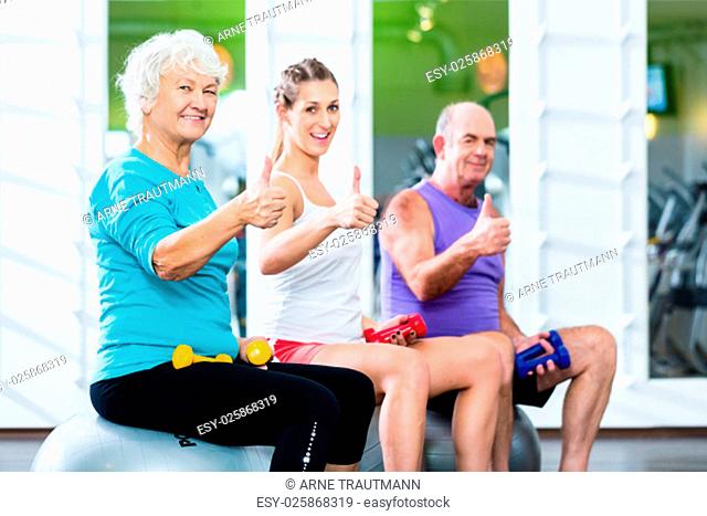 Senioren und Trainer mit Hanteln bei Fitness Sport