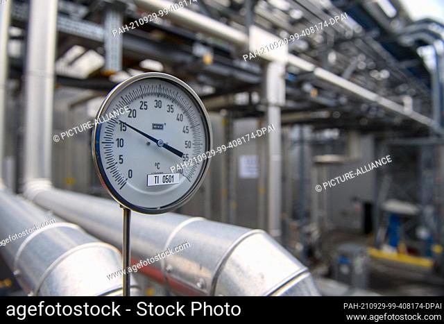 24 September 2021, Saxony-Anhalt, Genthin: A temperature display shows the outside temperature next to tank farms of the Verdant company at the Genthin Chemical...