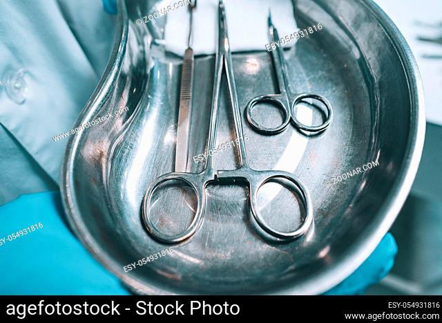 Several surgical instruments lie on a tray, close perspective