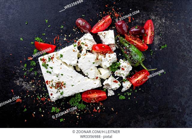 Traditional Greek Feta with Vegetable as top view on an old rusty metal sheet