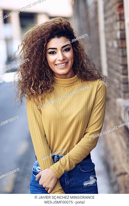 Portrait of smiling young woman with curly hair