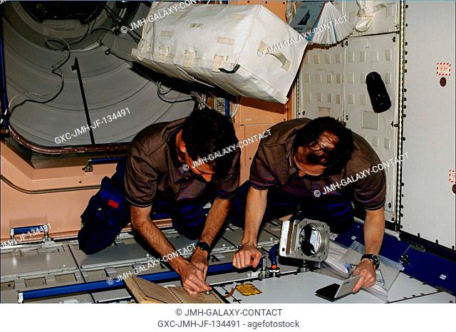 Astronaut Kent V. Rominger (left) and cosmonaut Valery I. Tokarev put on the finishing touches of their assigned chores in preparation of the International...