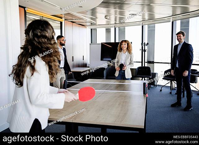Businesswomen playing table tennis enjoying with colleagues in office