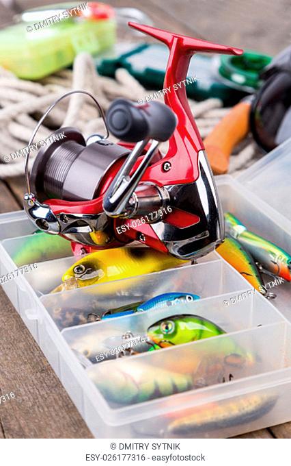 fishing tackles and baits in storage boxes with white cord and tools