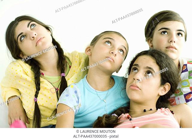 Four young female friends looking up